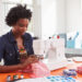 Image of a woman stitching fabric using a sewing machine. Representing a creative hobby such as arts and crafts.